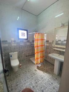 La salle de bains est pourvue de toilettes et d'un lavabo. dans l'établissement IDMAN RESIDENCE, à Ambouli
