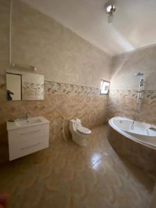La salle de bains est pourvue d'une baignoire, d'un lavabo et d'une baignoire. dans l'établissement IDMAN RESIDENCE, à Ambouli