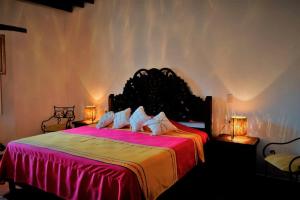 a bedroom with a large bed with a red and yellow blanket at Casa Orquídea con Alberca en Centro Histórico in Parras de la Fuente +73 photos