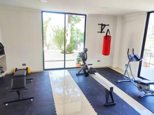 a gym with tread machines and a punching bag on the wall at Paradise in Envigado- in Envigado