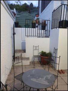 een patio met een tafel en stoelen en een gebouw bij Aderyn Mawr Cottage in Blaina