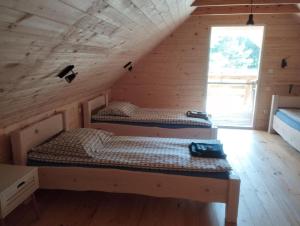 a bedroom with two beds in a wooden cabin at Brzozowy Zakątek in Budry