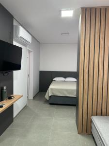 1 dormitorio con 1 cama y TV de pantalla plana en Loft Noruega, en Jaguarão