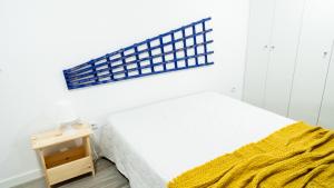 a bedroom with a bed with a yellow blanket on it at A Casinha do Ferreiro in Beja