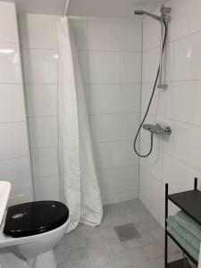 a white bathroom with a toilet and a shower at Mysigt centralt boende in Gothenburg
