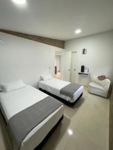 ein Hotelzimmer mit 2 Betten und einem Sofa in der Unterkunft Villa Mantra 