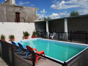 una piscina con sedie accanto a un edificio di Apartamentos El quincho a El Carmen
