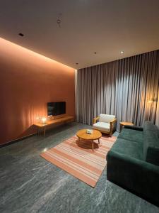 un soggiorno con divano verde e TV di Timber suites تمبر سويتس a Riyad