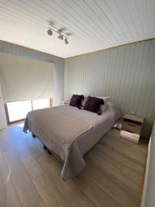 una camera con un grande letto e una finestra di Cabañas Los Robles a Coelemu