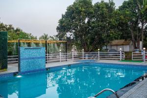 a swimming pool with a fence and blue water at Dandeli Kali River Stay in Dandeli