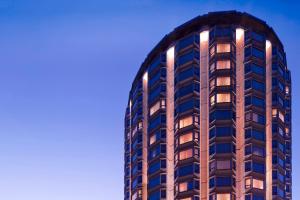 un edificio de apartamentos alto con luces encendidas en The Park Tower Knightsbridge, a Luxury Collection Hotel, London, en Londres