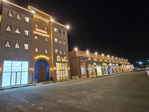 a building with lights on the side of a street at سيبار للشقق المخدومة Sippar Serviced Apartments in Hotat bani tamim