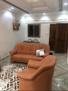 a living room with a couch and two chairs at MK Hebergement in Saint-Louis