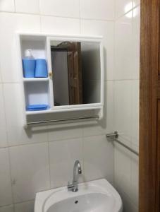 a white bathroom with a sink and a mirror at MK Hebergement in Saint-Louis