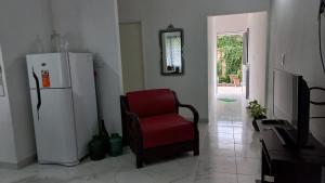 a living room with a red chair and a refrigerator at Lo de Julio in Lobos