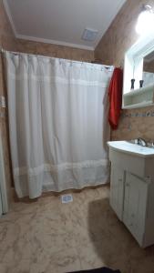 ein Badezimmer mit Duschvorhang und Waschbecken in der Unterkunft Lo de Julio in Lobos