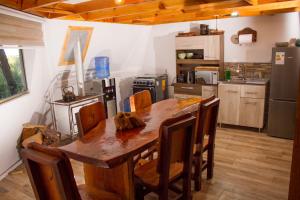 a large kitchen with a wooden table and chairs at Glamping Domo Valle de Rabones in Colbún Alto
