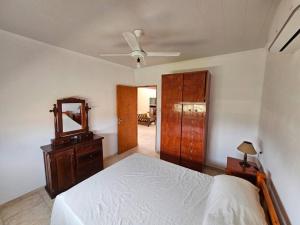 een slaapkamer met een bed, een dressoir en een spiegel bij Casa quinta Gabi in San José del Rincón