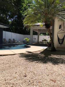 a house with a palm tree and a swimming pool at Casa Anna, Private Home, Guiones in Nosara