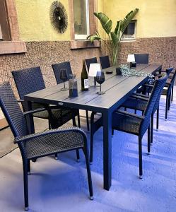 uma mesa de madeira com cadeiras e copos de vinho em Apartment Schwarzwaldgeflüster em Gernsbach