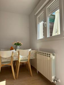 ein Esszimmer mit einem Tisch, Stühlen und einem Fenster in der Unterkunft Villa con patio in Madrid