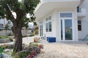 a white house with a door and a tree at B&B Alalama in Polignano a Mare