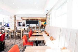 ein Restaurant mit Holztischen und roten Stühlen in der Unterkunft Hilton Garden Inn Denton in Denton
