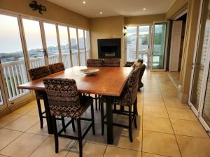 a dining room with a wooden table and chairs at Villa Penthouse 17-5 in Mossel Bay