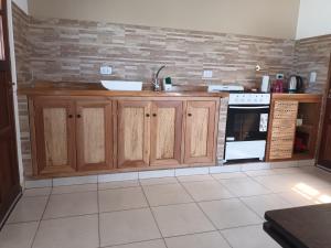 una cocina con armarios de madera y fregadero en La Justina - Alquiler Temporario en Cafayate