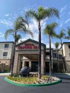 a building with palm trees in front of it at Hilton Garden Inn Montebello / Los Angeles in Montebello