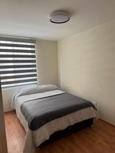 a bedroom with a bed and a window in a room at Dep completo a 5min del foro sol, y del aeropuerto in Mexico City