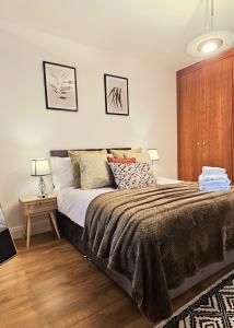 - une chambre avec un grand lit et une armoire en bois dans l'établissement Luxury 3 Bed Apt in Camden, à Londres