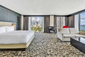 Habitación de hotel con cama, escritorio y sofá en Hilton Miami Downtown, en Miami
