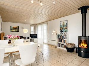 a living room with a fireplace and a table and chairs at Three-Bedroom Holiday home in Brovst 31 in Brovst