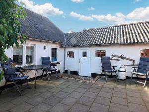 a patio with chairs and a table and a building at 5 person holiday home in Løkken-By Traum in Løkken