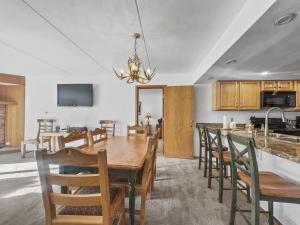 a dining room and kitchen with a wooden table and chairs at SL299 Spruce Lodge 2Br 2Ba condo in Copper Mountain
