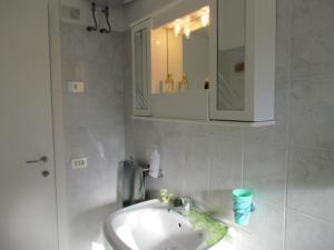 bagno con lavandino e specchio di Large Apartment for up to 9 guests - Great Location - Including Beach Place a Bibione