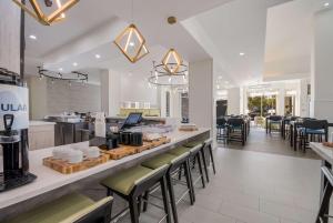 a restaurant with a counter with stools and a bar at Hilton Garden Inn Oklahoma City Midtown in Oklahoma City