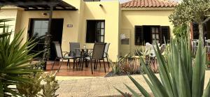 a patio with a table and chairs in front of a house at Casa La Pepita Las Lomas 117 in Caleta De Fuste
