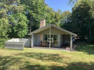 a small house with a porch with a table at Holiday home Løgstør IX in Løgsted