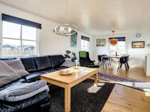 ロッケンにあるThree-Bedroom Holiday home in Løkken 9のリビングルーム(黒い革張りのソファ、テーブル付)