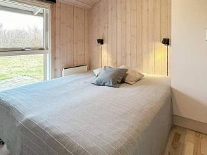 BrovstにあるHoliday Home Kronvildtvej IVのベッドルーム1室(大型ベッド1台、窓付)