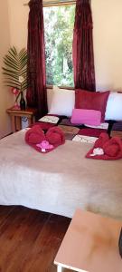 two beds in a room with red hats on them at Miriam'S Quetzals lodge in San Gerardo de Dota