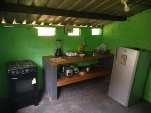 a small kitchen with a stove and a refrigerator at MI FUNDO in Acacías