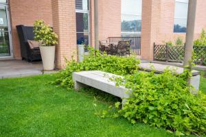 un banc en pierre assis dans l'herbe dans une cour dans l'établissement Hilton Garden Inn Santiago Airport, à Santiago