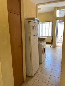 eine Küche mit einem Kühlschrank und einer Waschmaschine in der Unterkunft La casita de Morgan in Mercedes