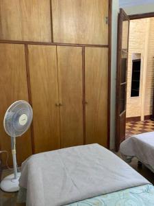 Schlafzimmer mit einem Bett, einem Ventilator und einem Schrank in der Unterkunft La casita de Morgan in Mercedes