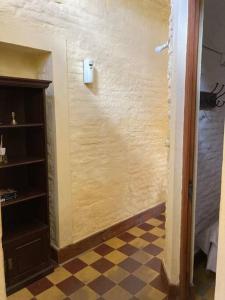um corredor com um quarto com uma parede com um piso de xadrez em La casita de Morgan em Mercedes
