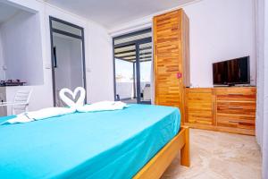 a bedroom with a blue bed and a television at Lotus Lane Apartments in Grand Baie