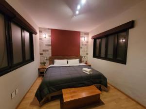um quarto com uma cama e duas janelas em Casa B & L Céntrico Departamento em Oaxaca de Juárez